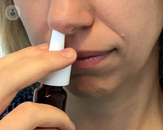 mujer usando un spray nasal 