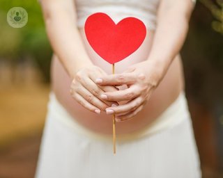 embarazada sosteniendo un corazon