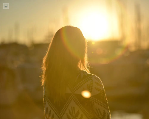 Chica de espaldas, en una puesta de sol - meditación - miedo al cambio - by Top Doctors